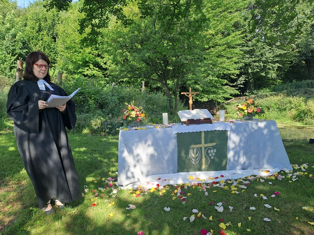 Pfarrerin Elena Bondarenko vor dem sommerlichen Altar an der Nettequelle Pfarrerin Elena Bondarenko vor dem sommerlichen Altar an der Nettequelle