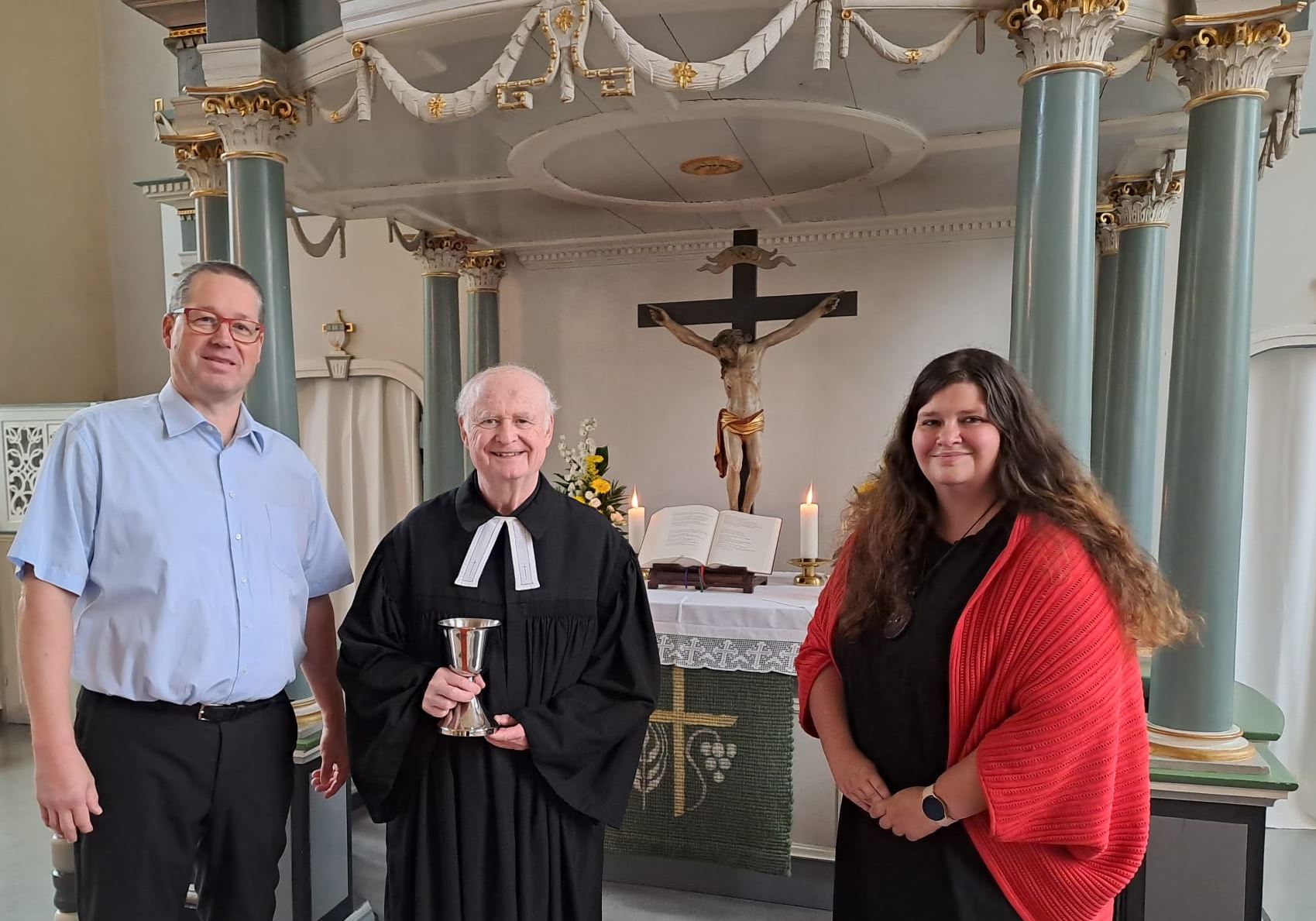 Übergabe des Abendmahlskelch an die Gemeinde Herrhauensen (von links Christian Appun, Pastor Wolf-Ulrich Wentzel, Melanie Reinecke) 2022 09 09 Gottesdienst mit Abendmahlskelch