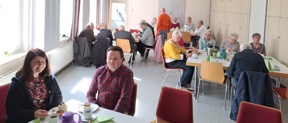 Im Vordergrund Pfarrerin Elena Bondarenko mit Ehemann Artis Petersons im DGH während des Geburtstagskaffees, Foto: C. Appun